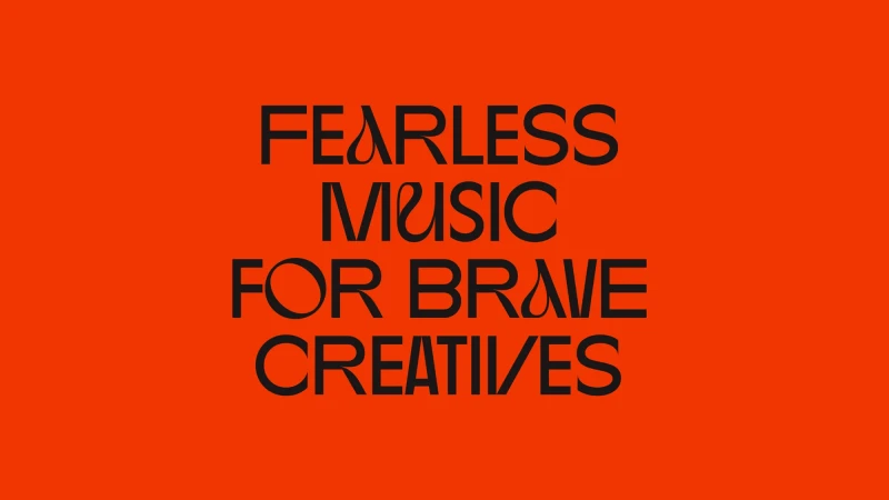 Graphic design with the text 'Fearless Music For Brave Creatives' in a bold sans-serif font against a solid orange background.