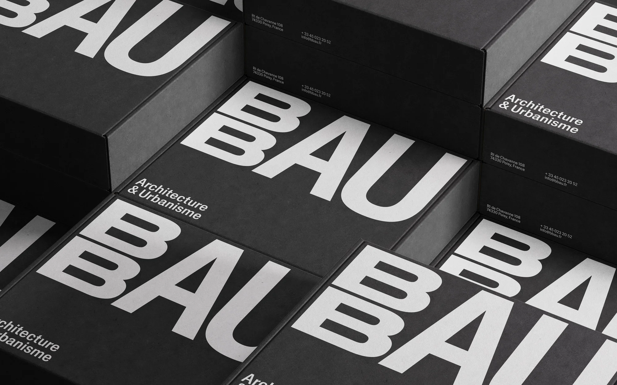Stack of black boxes with bold white 'BAU' typography for architecture & urbanisme, creating a modern, geometric design.