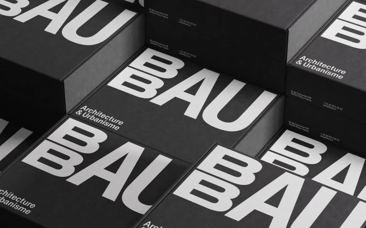Stack of black boxes with bold white 'BAU' typography for architecture & urbanisme, creating a modern, geometric design.