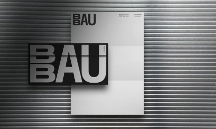BBAU brand identity presentation featuring typography-focused graphic design on paper placed against corrugated metal