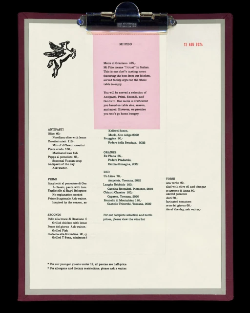Restaurant menu on a clipboard. The menu is cream colored with a pink insert, featuring text and a pegasus logo.