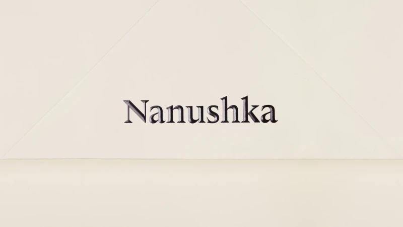 Studio shot of a Nanushka package, displaying the brand logo and a geometric design on a neutral background.