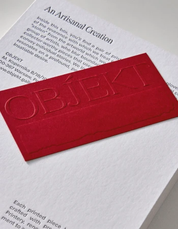 Close-up of a product box with embossed brand name 'Objekt' on a red card, featuring descriptive text about an artisanal creation.