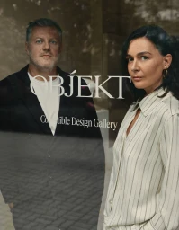 Portrait of a man and woman visible behind glass storefront window with OBJEKT Collectible Design Gallery branding