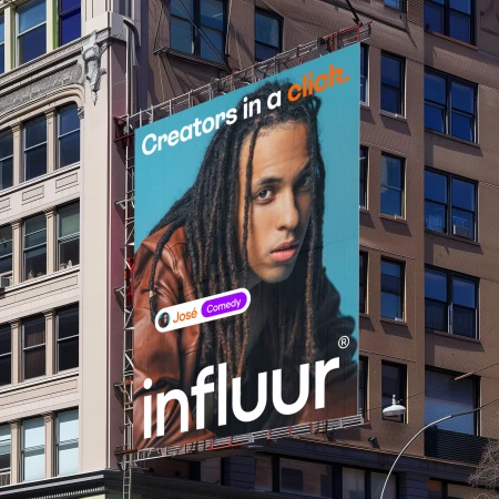 Billboard advertisement on a building featuring a man with dreadlocks and the text 'Creators in a click' and 'Influur' on a building.
