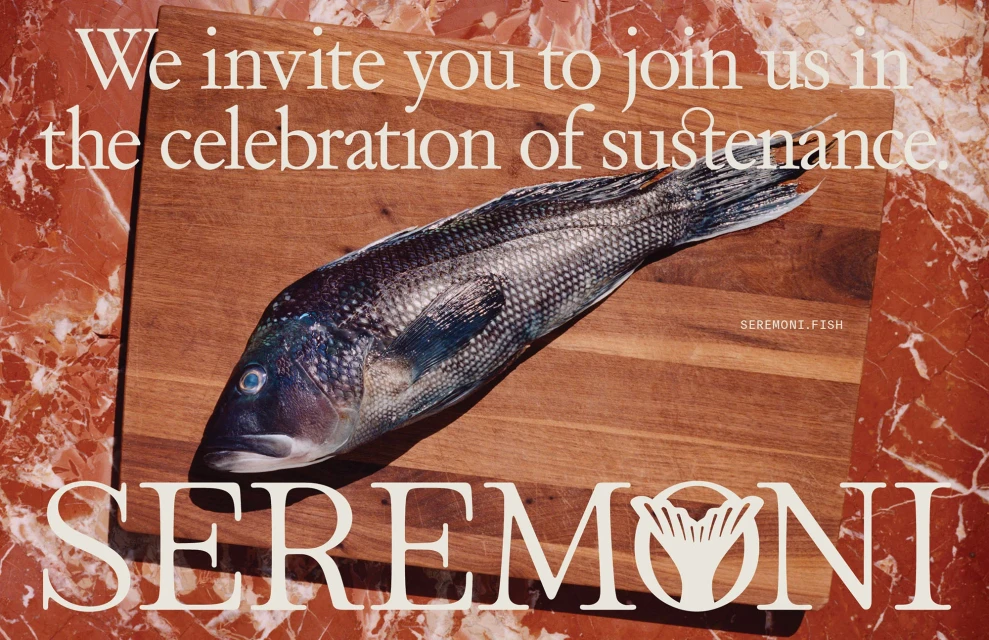 Overhead shot of a fresh raw fish on a wooden cutting board, presented on a red marble surface with promotional text.