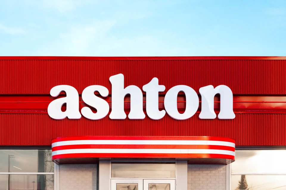 Exterior shot of an Ashton restaurant featuring a red and white color scheme, emphasizing architectural details and signage against a clear sky.