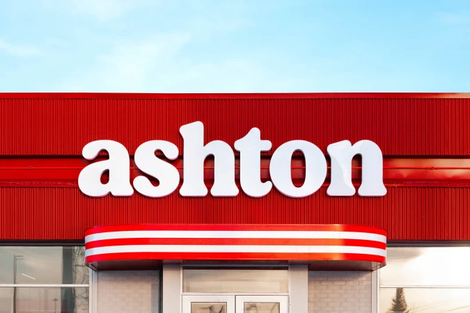 Exterior shot of an Ashton restaurant featuring a red and white color scheme, emphasizing architectural details and signage against a clear sky.