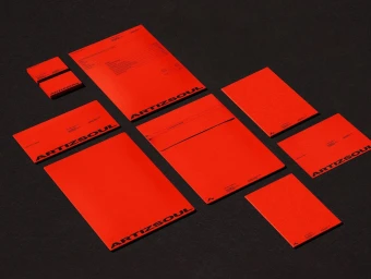 Flat lay of vibrant red stationery items featuring custom typography arranged neatly on a dark textured surface.