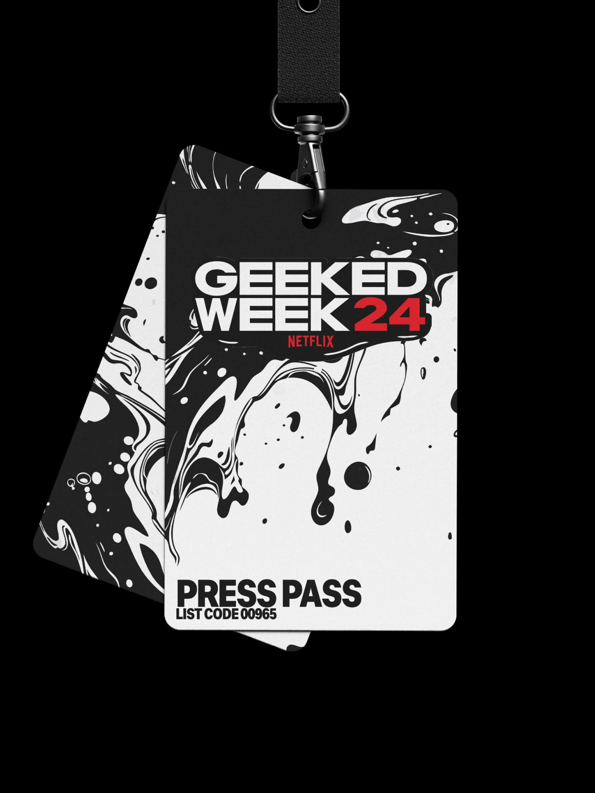 Two press passes with the text "Geeked Week 24 Netflix" hang from black lanyard. One pass has black and white ink blot design.