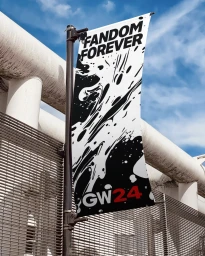 Vertical banner reading FANDOM FOREVER and GW24 mounted on a dark pole against a white architectural structure and blue sky