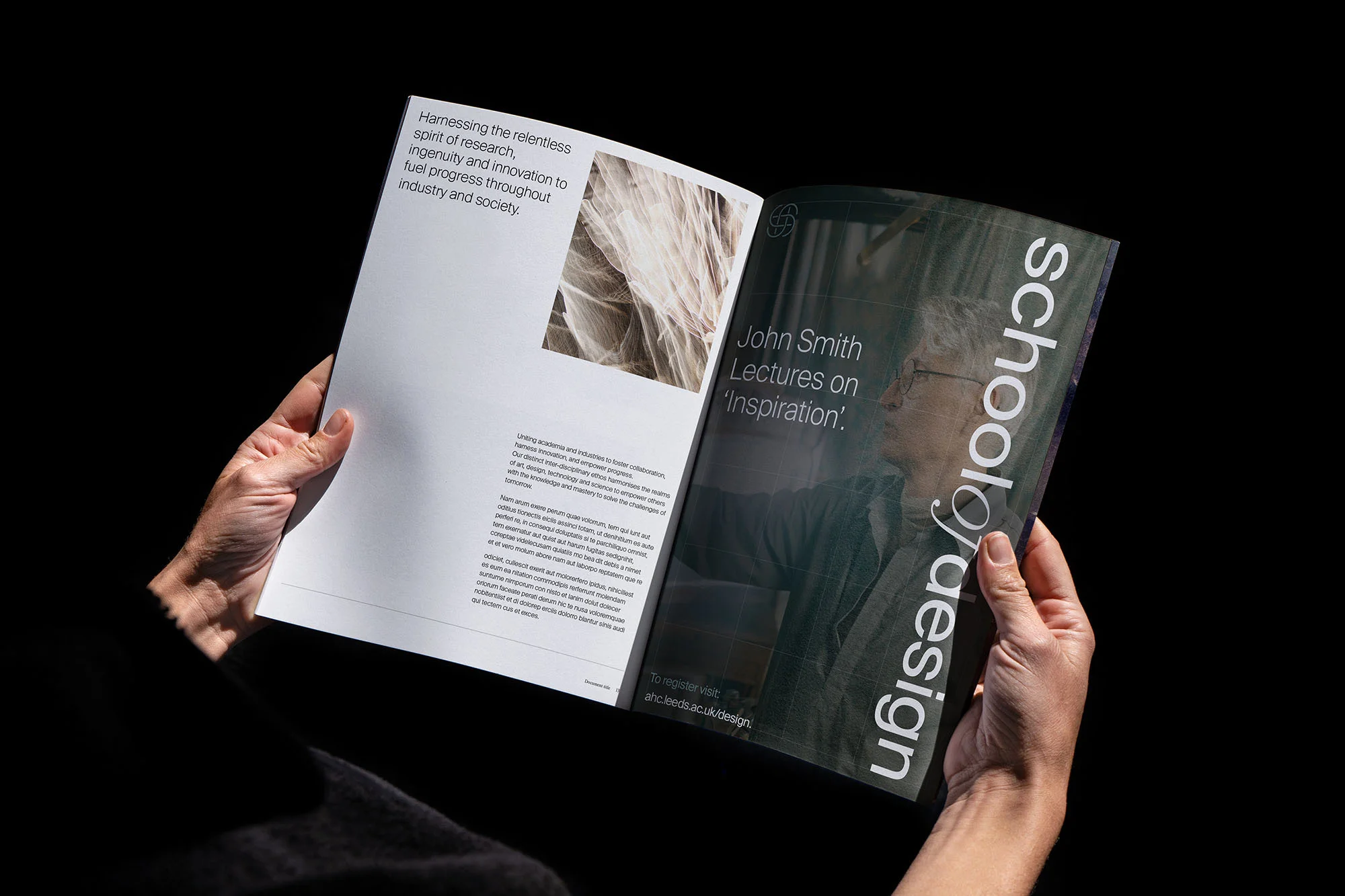 Close-up of hands holding open a magazine with text and image of a person, emphasizing design and lectures on inspiration.
