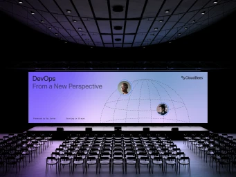 Wide shot of a dark auditorium facing a large glowing presentation screen displaying DevOps From a New Perspective with CloudBees branding.