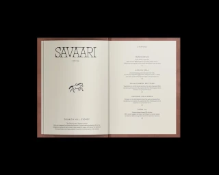 Open menu booklet with Savaari branding, horse illustration, and starters list on off-white paper.