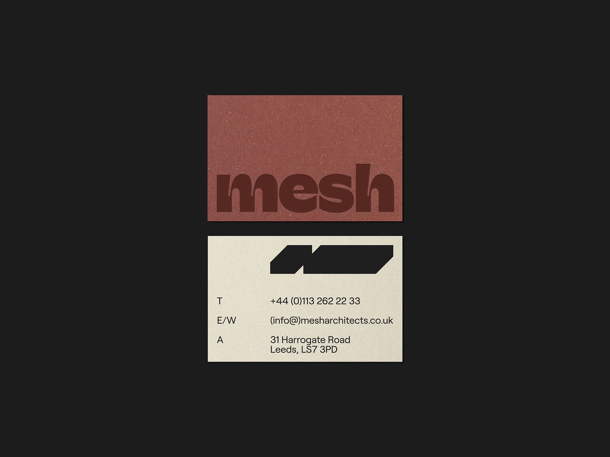 Close-up studio shot of two business cards, one with the word 'mesh' in bold font and the other with contact information.