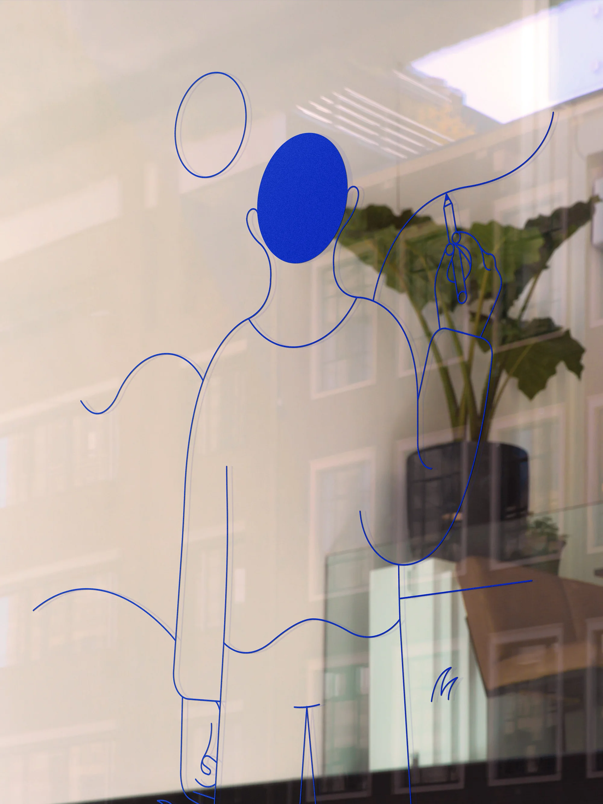 Line art on glass depicts a figure drawing on an interior window, with reflections of buildings and a potted plant visible.