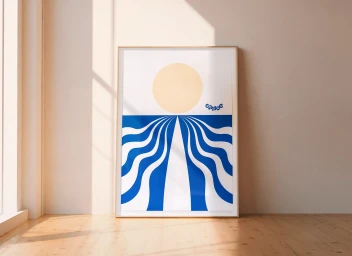 Framed graphic art print featuring a golden sun and blue wave patterns leaning against a light wall on a wooden floor.