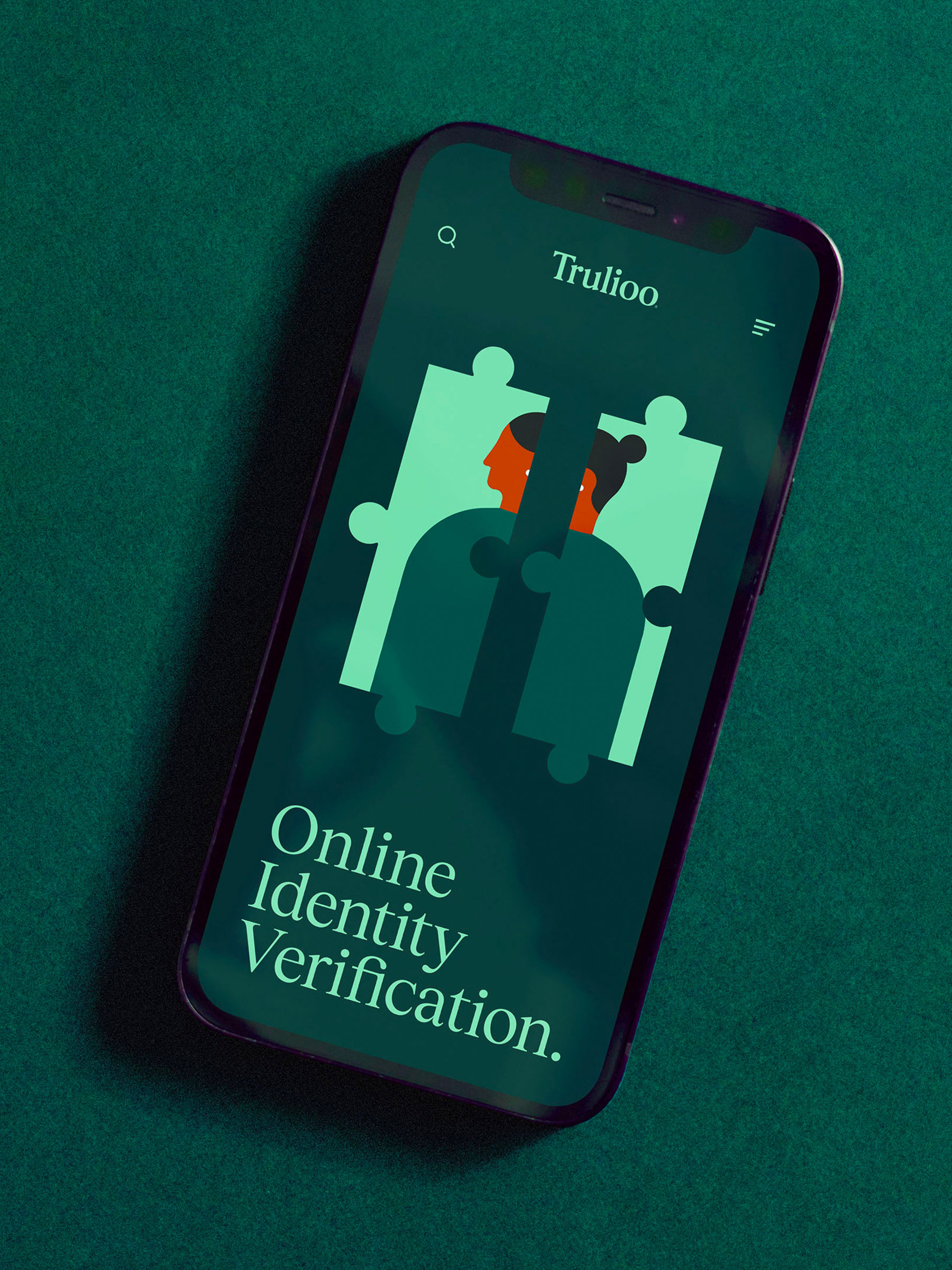 Close-up of a smartphone displaying Trulioo online identity verification app with a puzzle design, set against a green backdrop.