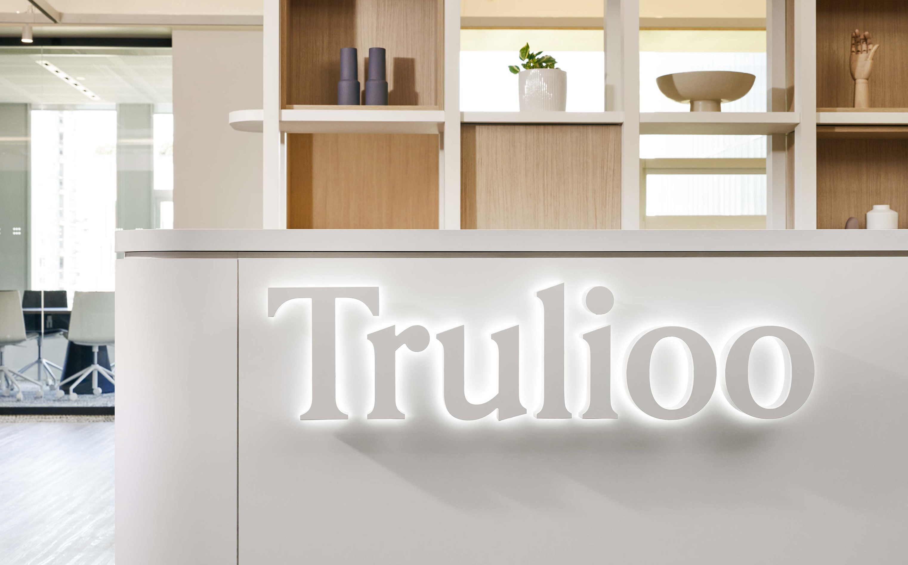 Bright, modern office reception area featuring the 'Trulioo' company sign, showcasing a clean and welcoming workspace design.