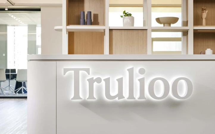Bright, modern office reception area featuring the 'Trulioo' company sign, showcasing a clean and welcoming workspace design.