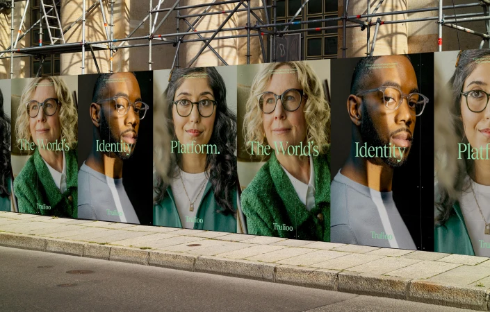 Outdoor advertising features diverse adults wearing glasses on a city street, promoting a brand identity platform.