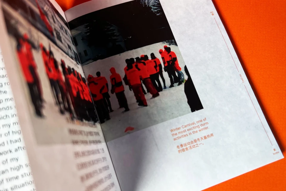 A magazine shows photos of people wearing orange jackets in a snowy outdoor setting. The article mentions a winter carnival.