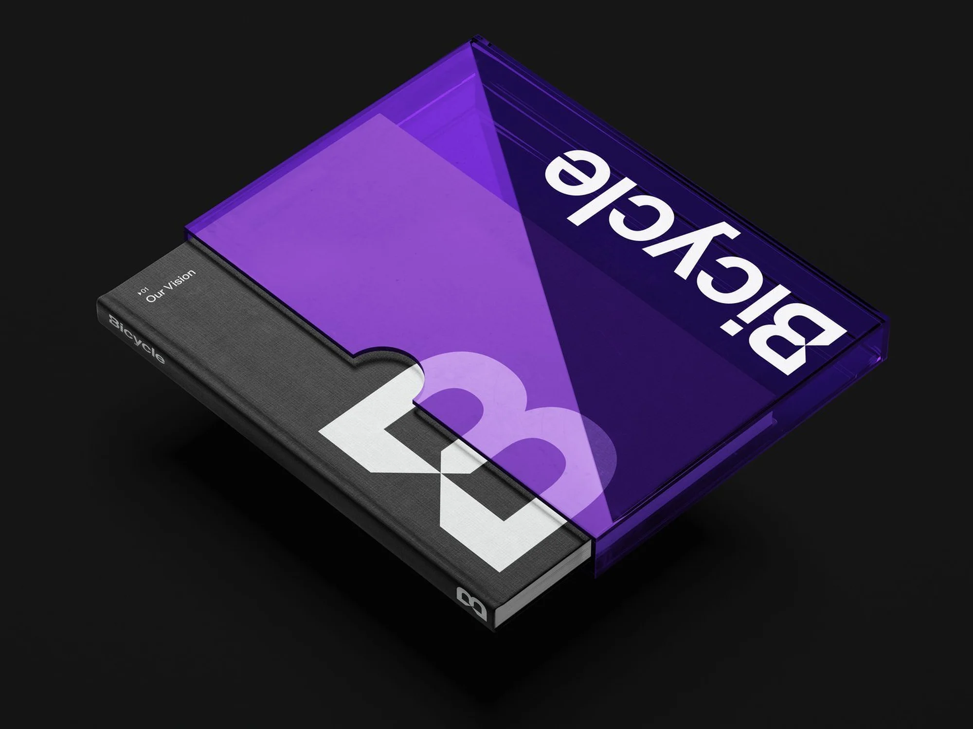 Book with black cover and a transparent purple sleeve with the word Bicycle written in white, against a dark grey backdrop.