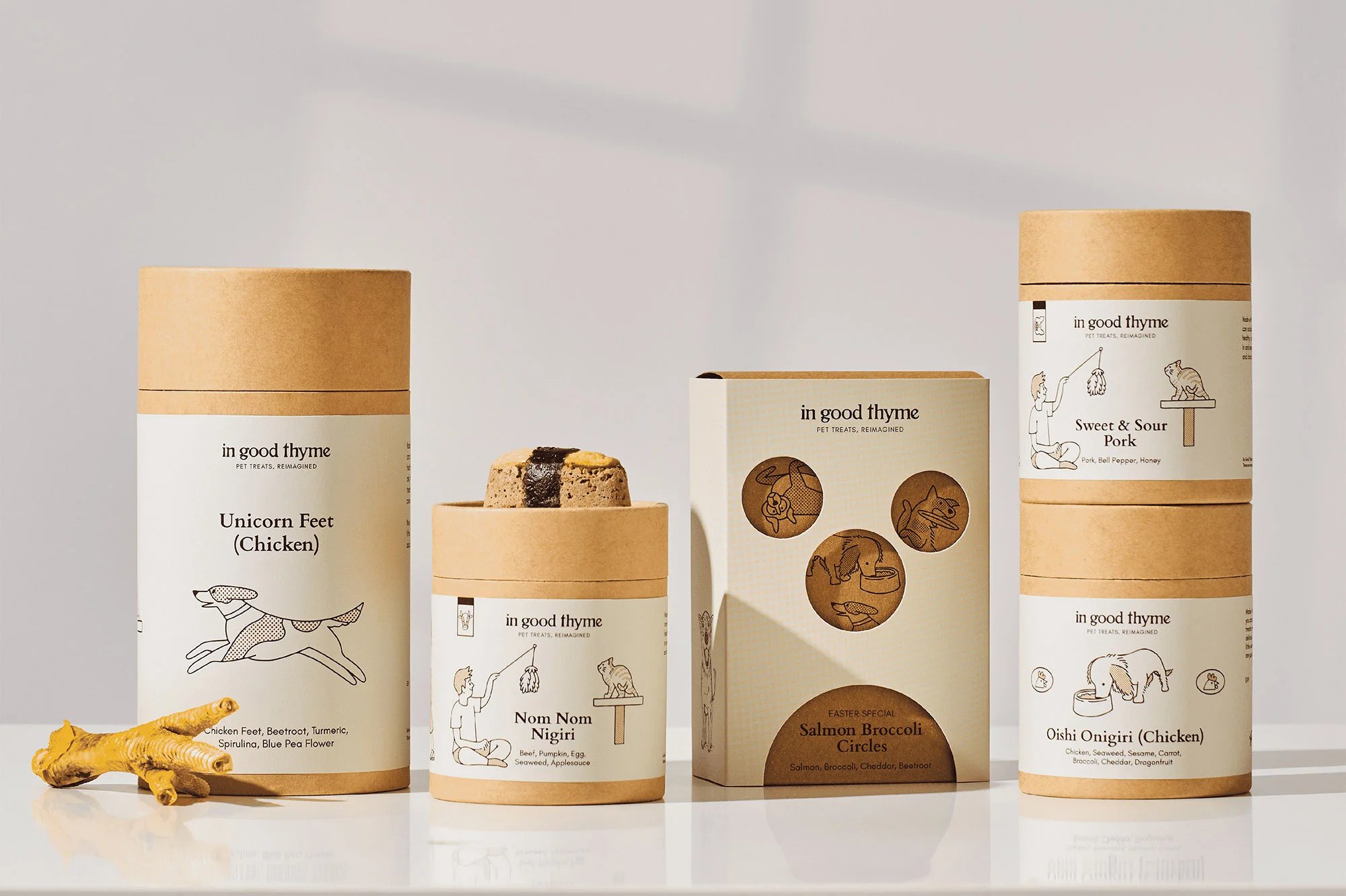 Assortment of In Good Thyme pet treat packaging including 'Unicorn Feet' chicken flavor and 'Salmon Broccoli Circles'.