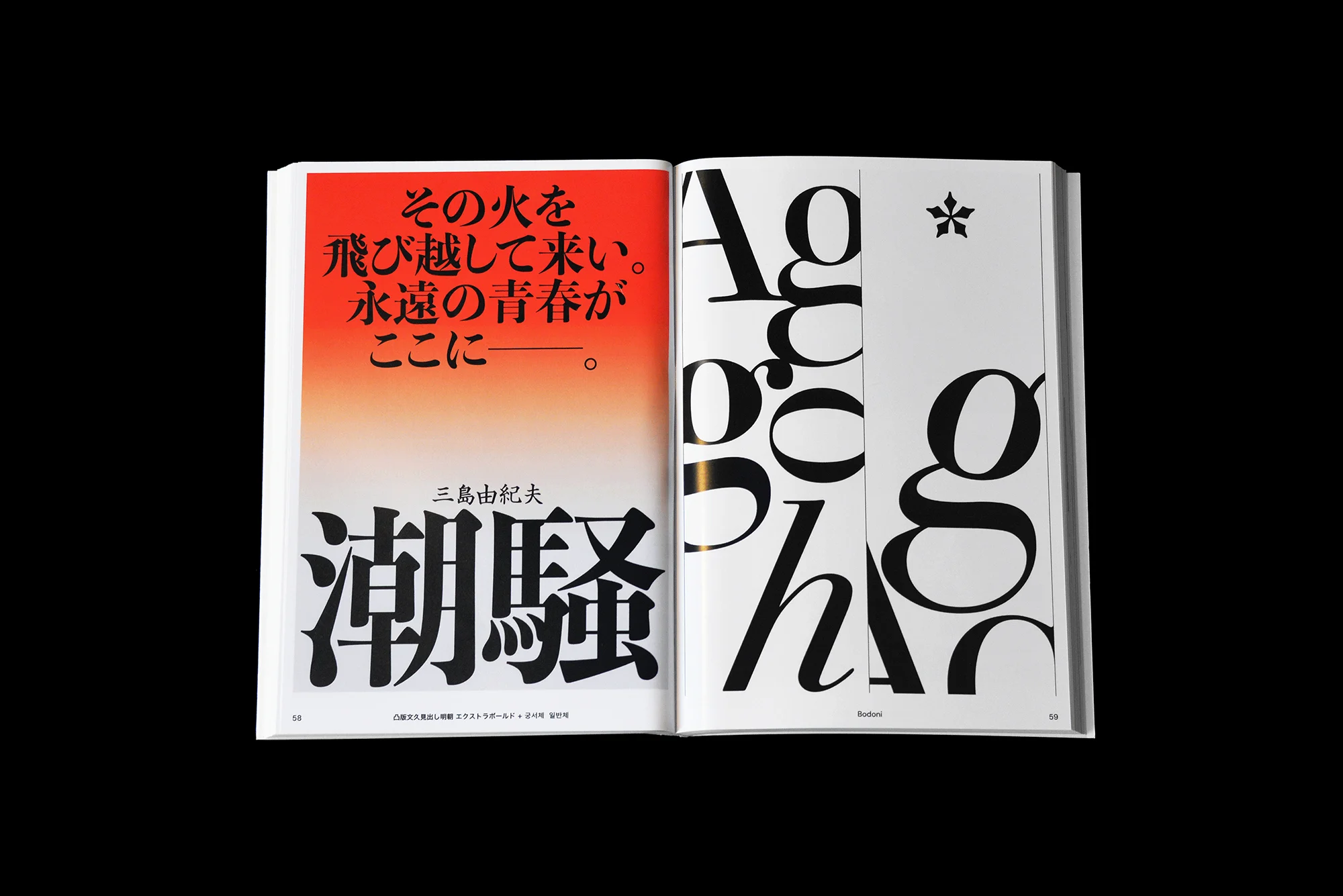 Open book displaying Japanese typography and graphic design layout with bold, contrasting colors and text on facing pages in a studio setting.