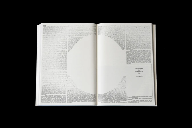 Open book with a text-based art piece in the center, featuring the words 'Paragraphs on Conceptual Art' by Sol LeWitt.