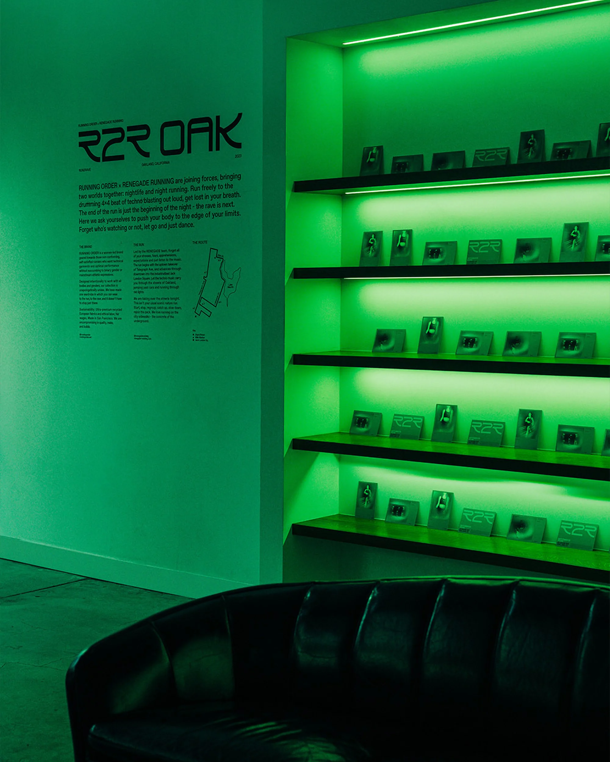 Showcase of R2R Oak artwork and displays, featuring illuminated shelving, promotional text on the wall, and a black leather sofa.