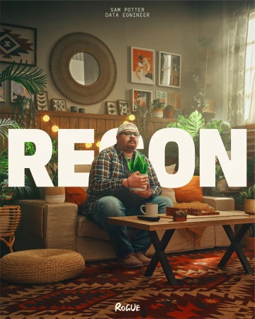 An adult male sits on a neutral-toned couch in a warmly lit living room, holding a potted plant, with the word 'RECON' overlaid.