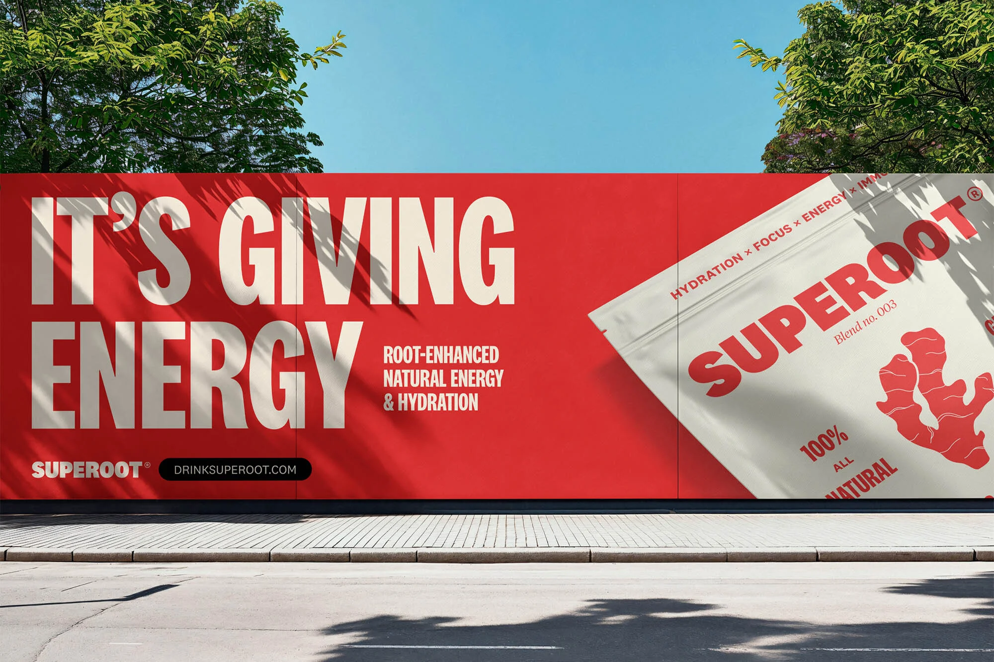Product advertisement on a wall featuring Superoot, a root-enhanced natural energy drink, with trees and blue sky visible above the wall.