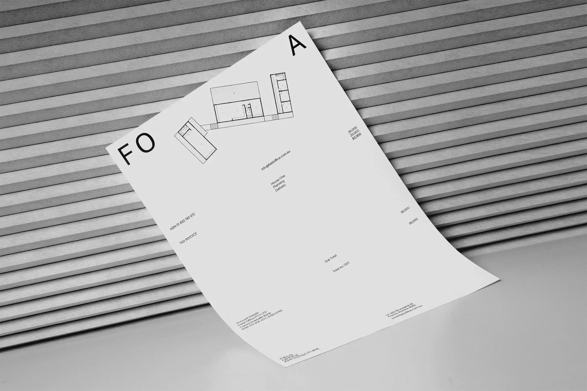 Architectural blueprint lies against a textured wall, featuring geometric lines and shapes in monochrome, suggesting design planning.