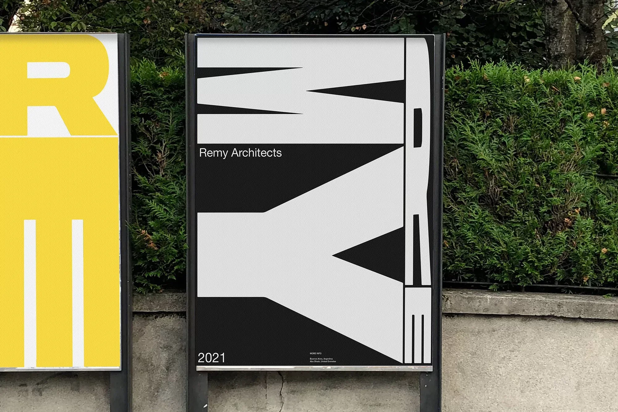Two architectural posters side-by-side, one with yellow text, the other with a black and white graphic design, outdoors.
