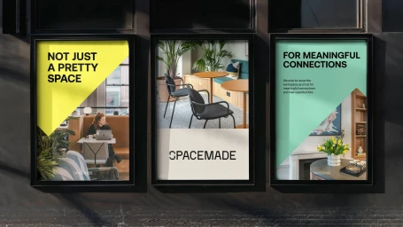 Three framed advertising posters mounted on a dark exterior wall for Spacemade brand identity featuring graphic design and interiors.