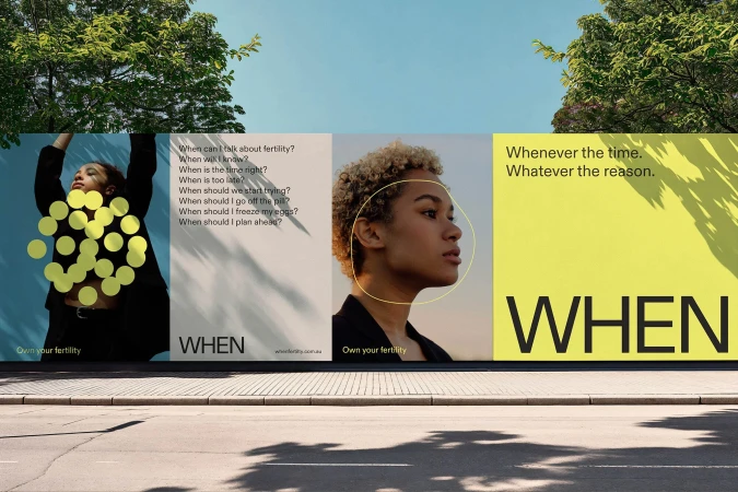 Eye-level shot of an outdoor billboard featuring two young women and text about fertility awareness against a clear blue sky background.