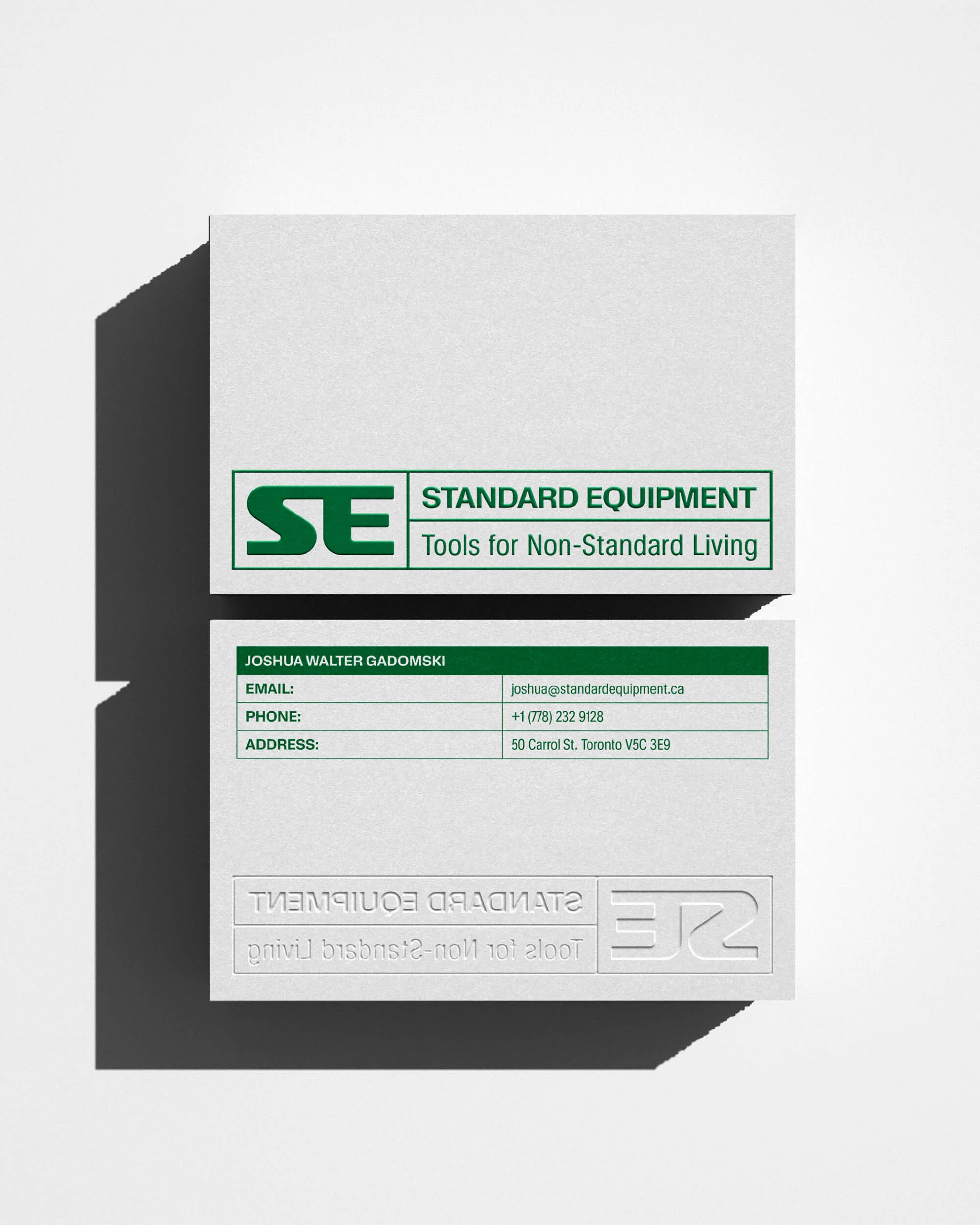 Two business cards are stacked on a white surface, showcasing a logo, company name, and contact information with clean design.