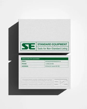 Two business cards are stacked on a white surface, showcasing a logo, company name, and contact information with clean design.