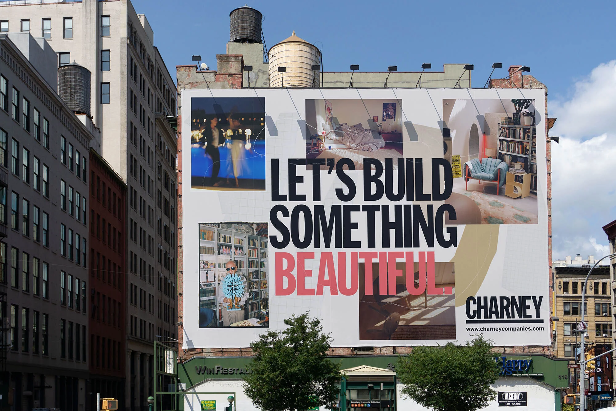 Large billboard on a city building with an advertisement featuring interior design photos and the text 'Let's Build Something Beautiful'.