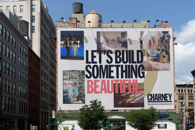 Large billboard on a city building with an advertisement featuring interior design photos and the text 'Let's Build Something Beautiful'.