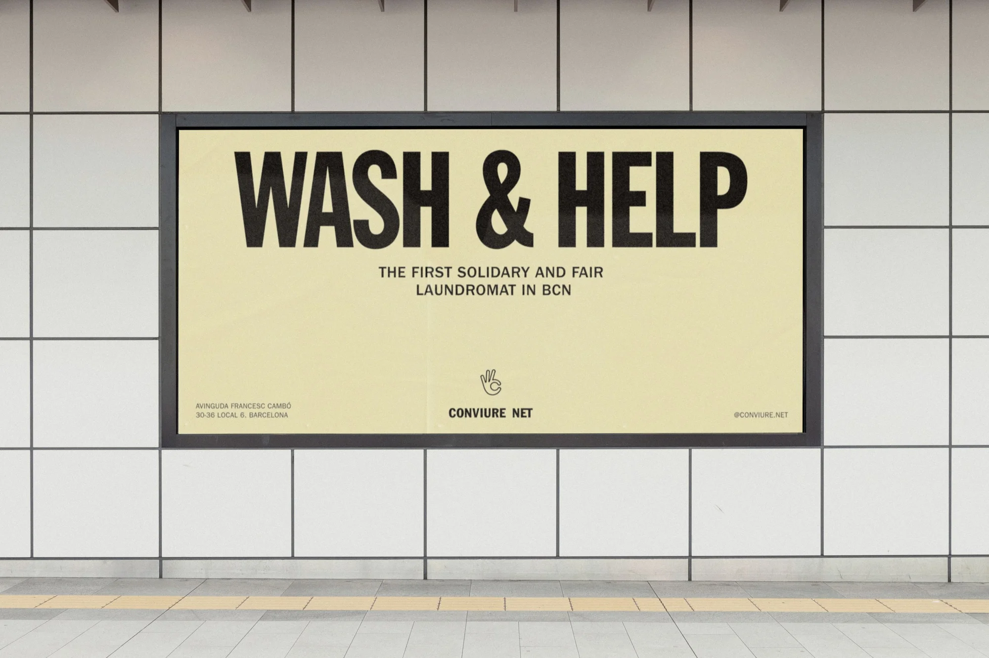 Indoor shot of an advertisement promoting 'Wash & Help,' the first solidary and fair laundromat in Barcelona, placed inside a subway station.