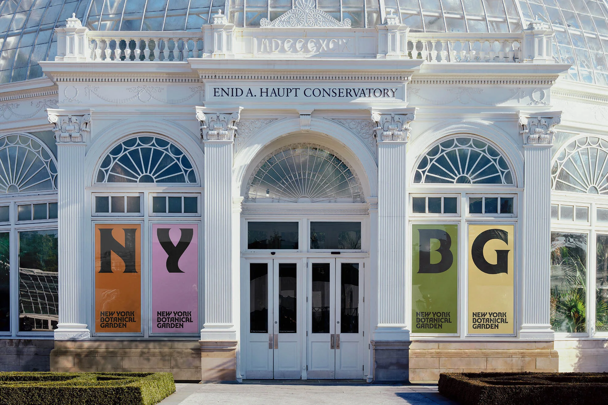 Exterior of the Enid A. Haupt Conservatory at the New York Botanical Garden with decorative white architecture and signage.