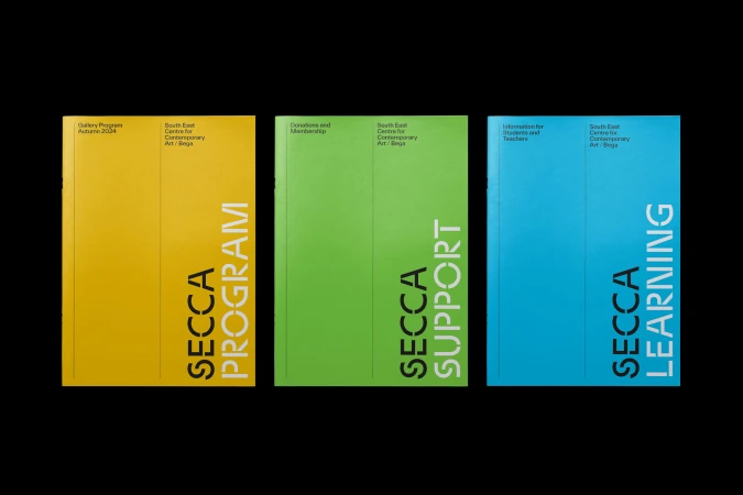 Three colorful SECCA program covers in yellow, green, and blue, stacked against a black background, displaying modern typography.