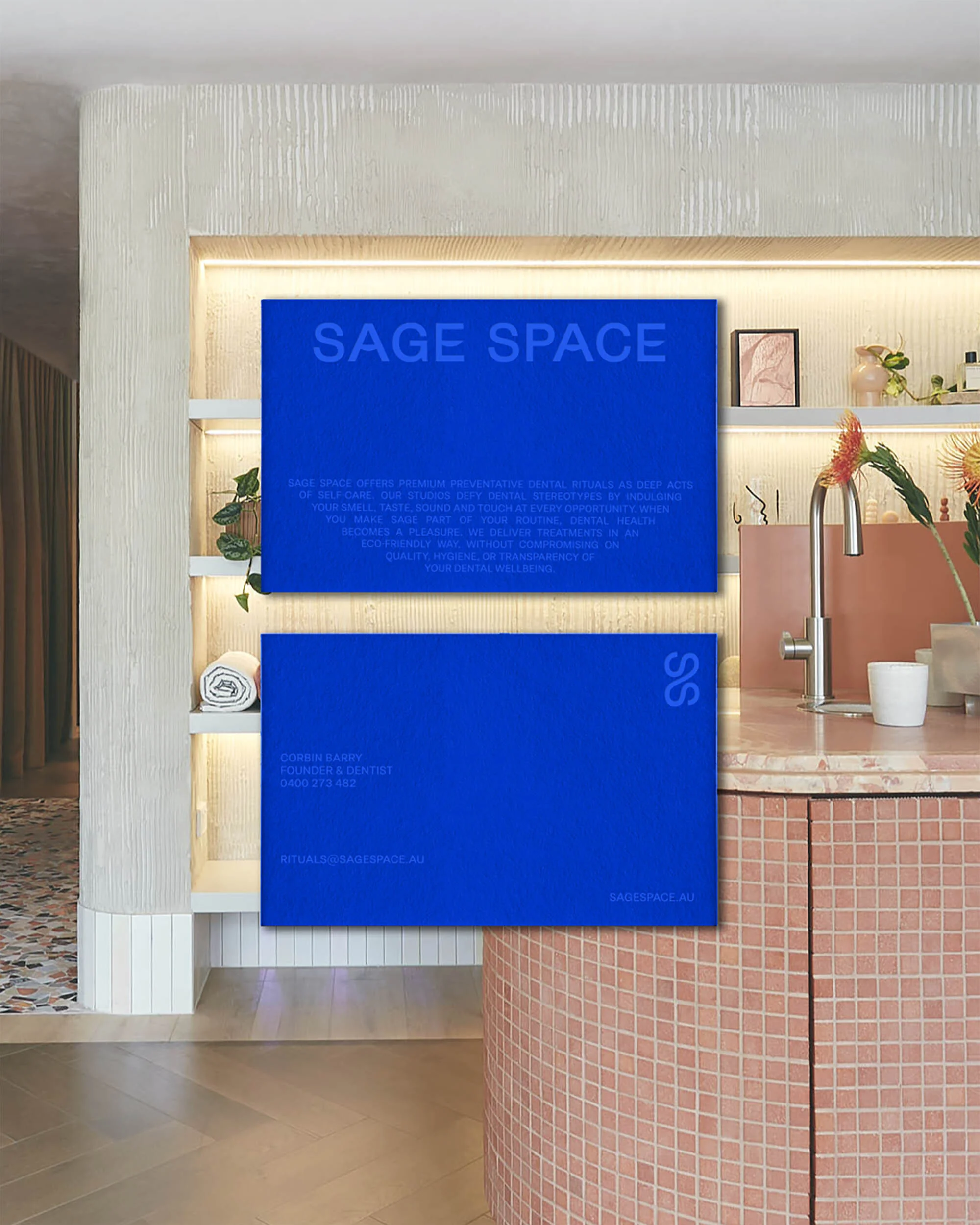 Two blue cards with the text 'Sage Space' displayed in an interior with a sink and cabinetry, illuminated by soft, indirect lighting.