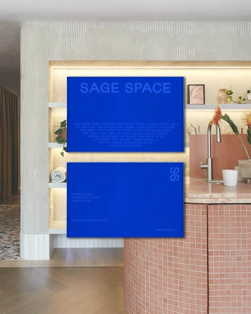 Two blue cards with the text 'Sage Space' displayed in an interior with a sink and cabinetry, illuminated by soft, indirect lighting.