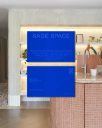 Two vibrant blue business cards featuring the Sage Space brand identity displayed against a contemporary interior background.