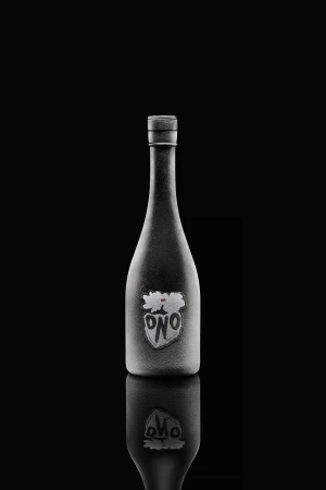 Dark-tone product shot of a wine bottle with a white label, mirrored reflection on a black surface.