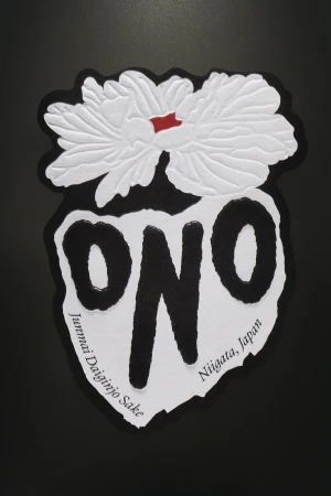 A sake label featuring a stylized flower, the word "ONO", and the text "Junmai Daiginjo Sake Niigata, Japan" against a black background.