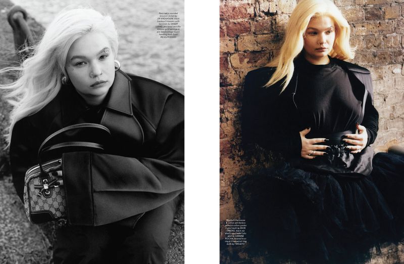 Editorial fashion shot featuring a woman with platinum blonde hair wearing a black coat and holding a Gucci handbag in an outdoor setting.